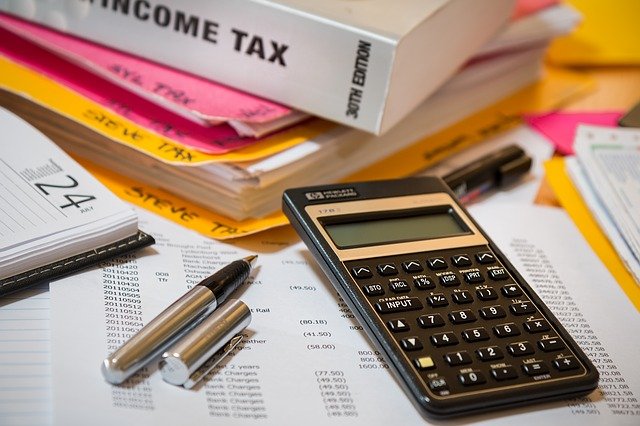 income tax books, papers and calculator